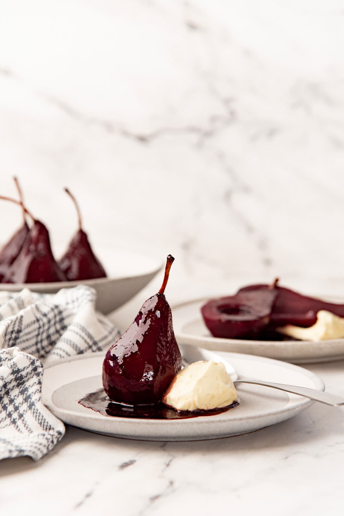 Side view of serving poached pears with spiced syrup and mascarpone.